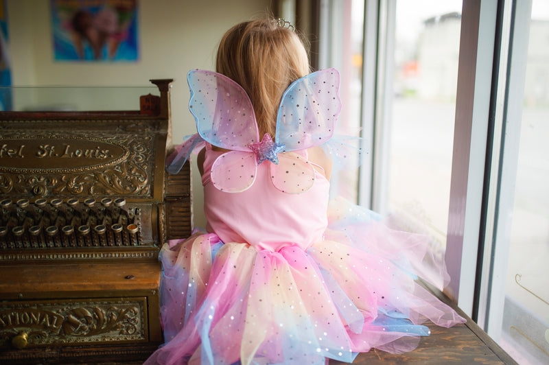 a girl wears the great pretenders rainbow fairy dress costume