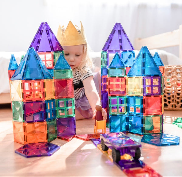 a child builds two large castles with the connetix tiles magnetic 212 piece set 
