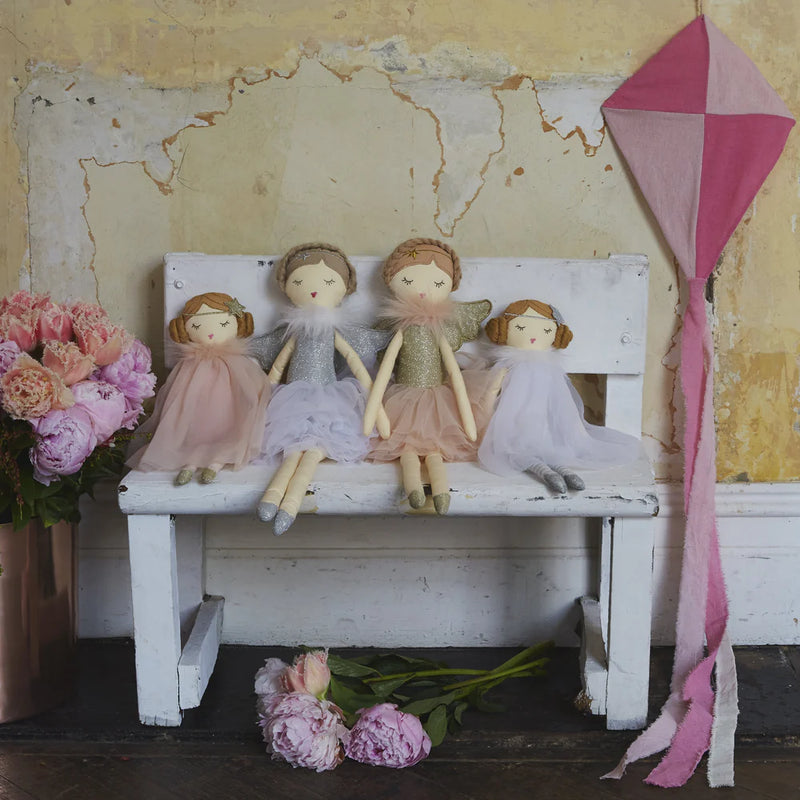 a collection of nana hutchy dolls with sleeping eyes sitting on a white wooden bench