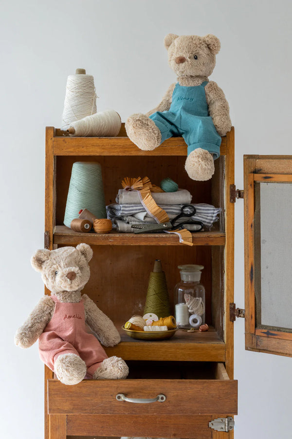 two soft toy bears sitting on the shelf 