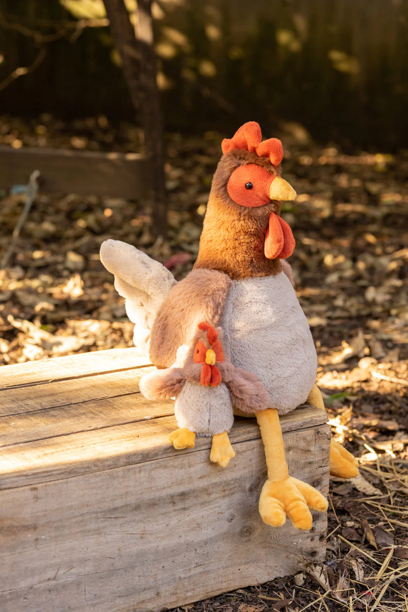 a rooster and baby rooster soft toys sitting on the bench