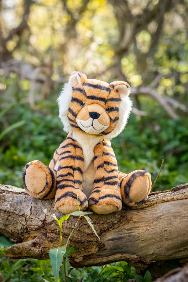 nana huchy tiger soft toy sits on a tree log outside