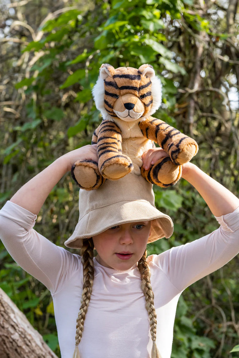 a girl holds her nana huchy tiger on her head playing outside