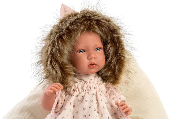 Baby doll wearing a fluffy hooded outfit on a white background