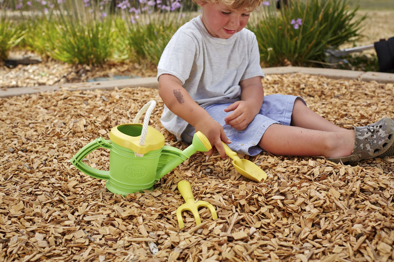 a child digging with his green toys yellow spade