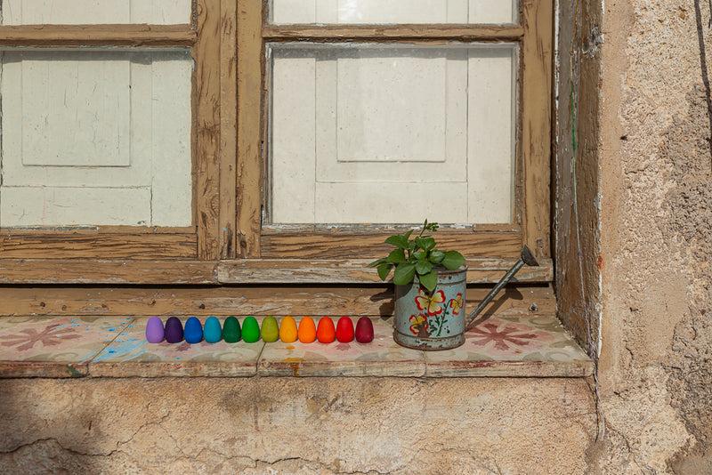the grapat mandala wooden eggs are resting on a window sill 