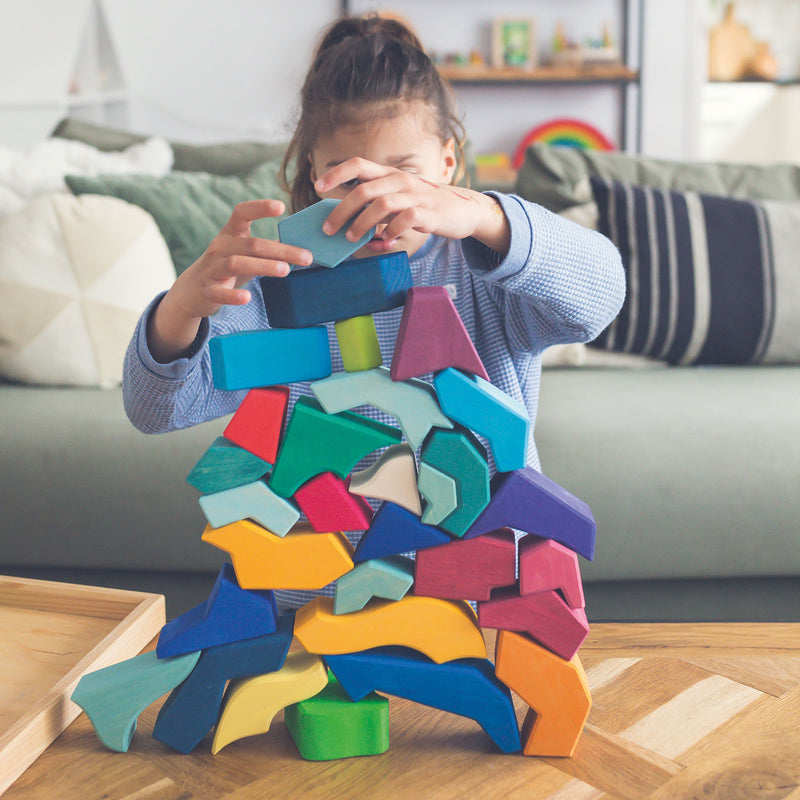 a child builds the four temperaments rainbow block puzzle up into a tower