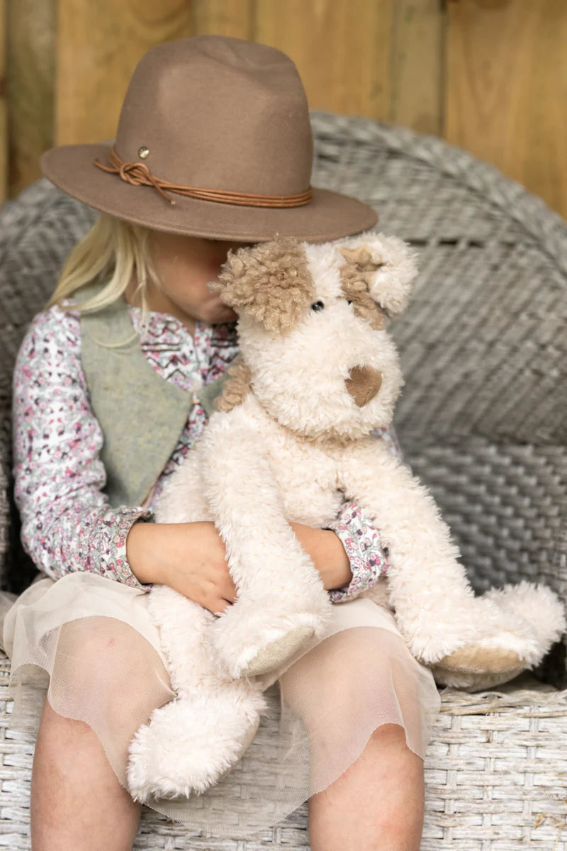 a child holds her buddy the dog soft toy