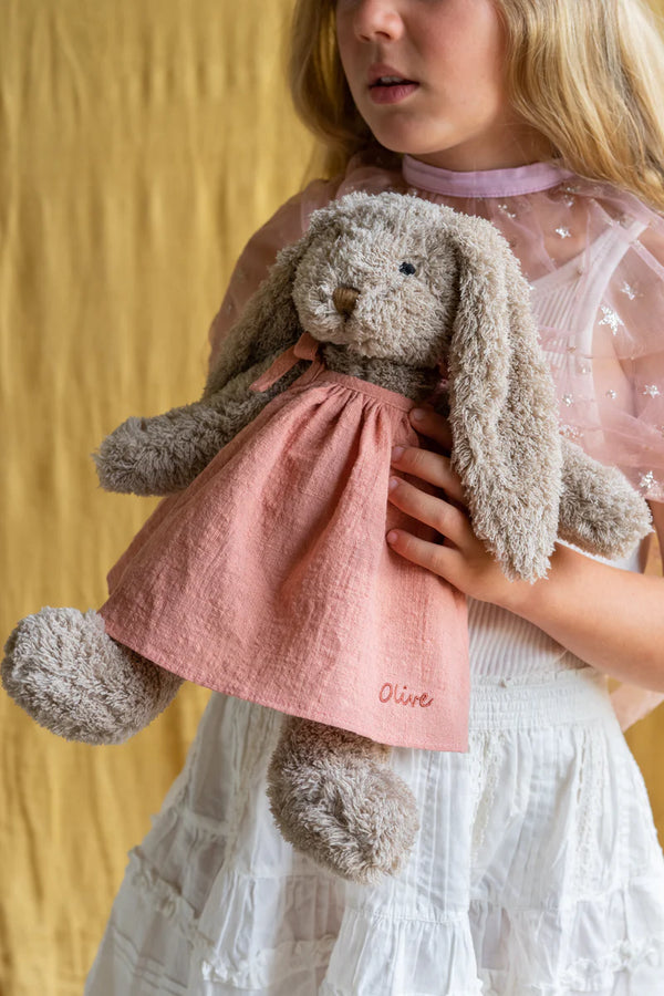 a child holds onto her honey bunny soft toy