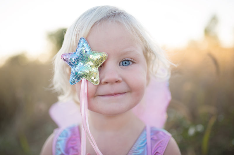 girl wears her great pretenders princess costume with sequin wand