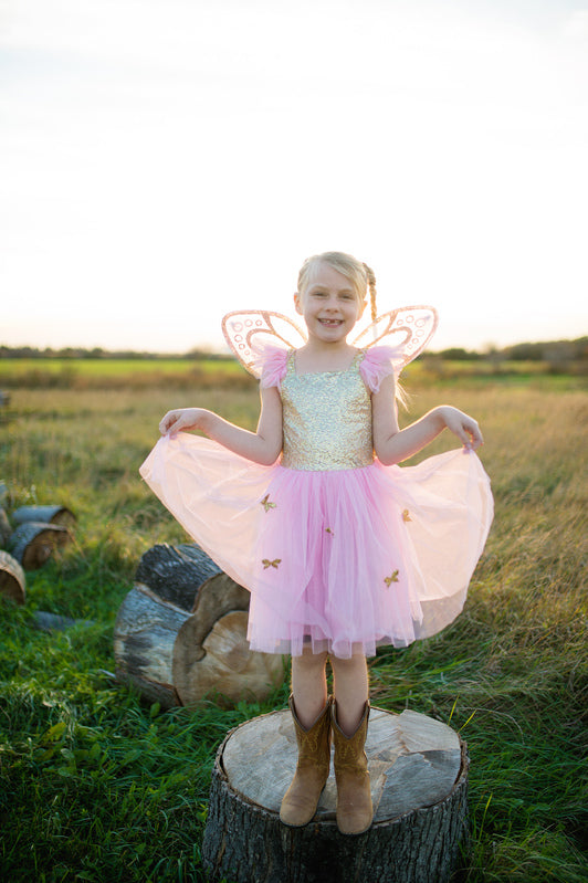 a girl wears a pink and gold butterfly costume
