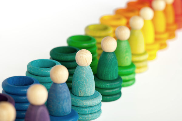 A close up mage of the rich rainbow colours of the Grapat wooden figures, rings and coins.