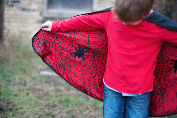 showing the inside of the kids costume cape with the red and black spider man print on the inside