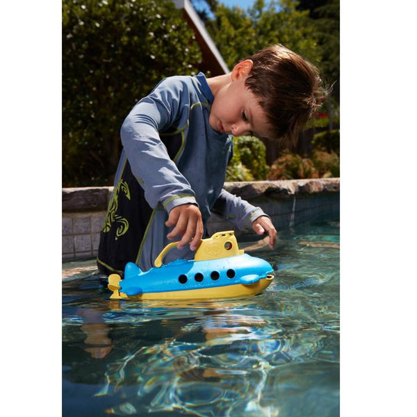 a child plays with the green toys submarine toy in blue and yellow
