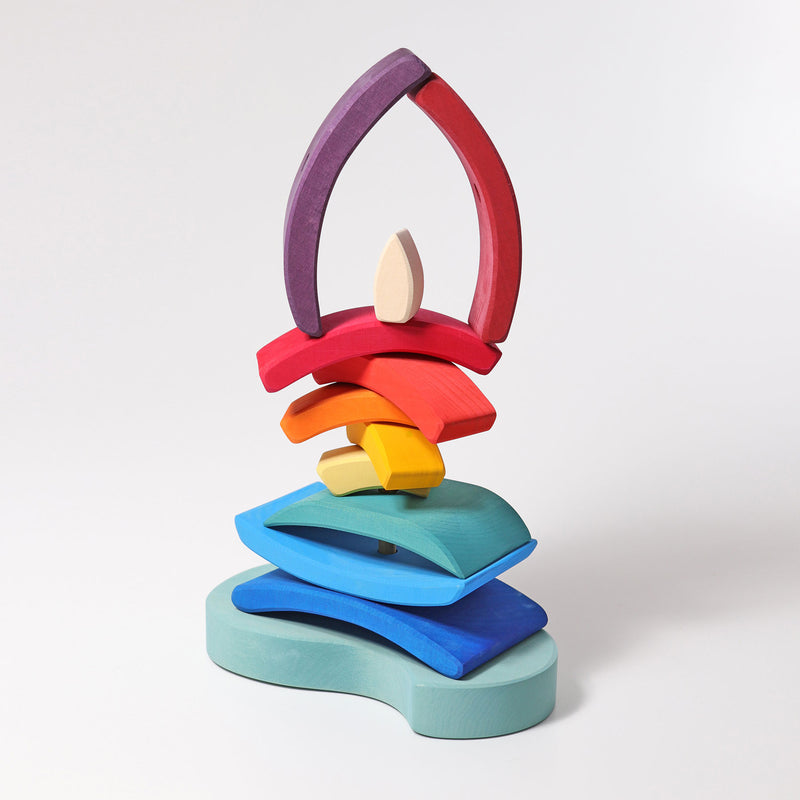 a grimms wooden stacking boat toy arranged in a balanced tower