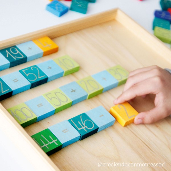 a child practices maths with the grimms wooden counting blocks