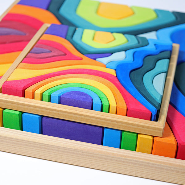 the grimms small four elements wooden puzzle resting over the large version the pieces are very bright and colourful