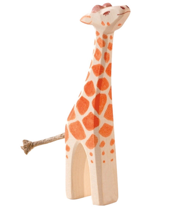 a small wooden giraffe with his headhelp up by ostheimer wooden toys