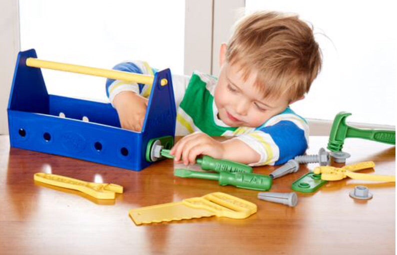 a child tightens a bolt with his green toys screwdriver and tool kit