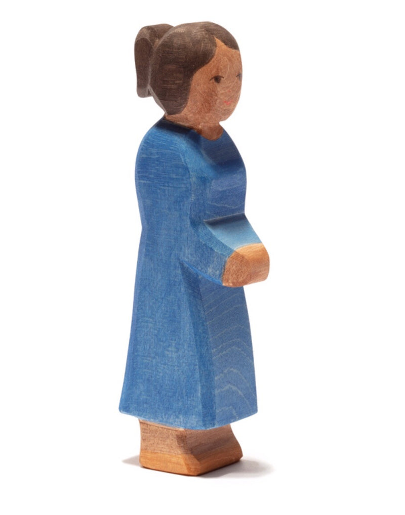 a wooden figure of a lady with a blue dress hand carved from wood