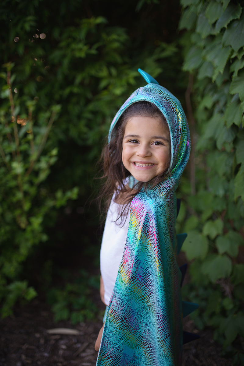 a girl faces the front smiling she is wearing the unicorn and dragon costume for kids showing the shiny scales of the dragon side