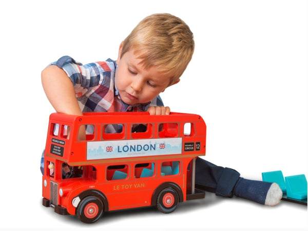 A young child playing with the wooden  Le Toy Van London Bus. Opening the top of the bus is an interactive feature. Recommended age 3 + 