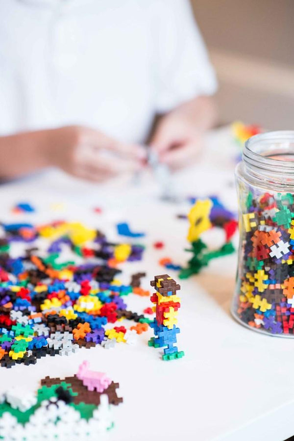 Plus plus building constructions pieces scattered on the table and ready for creative play