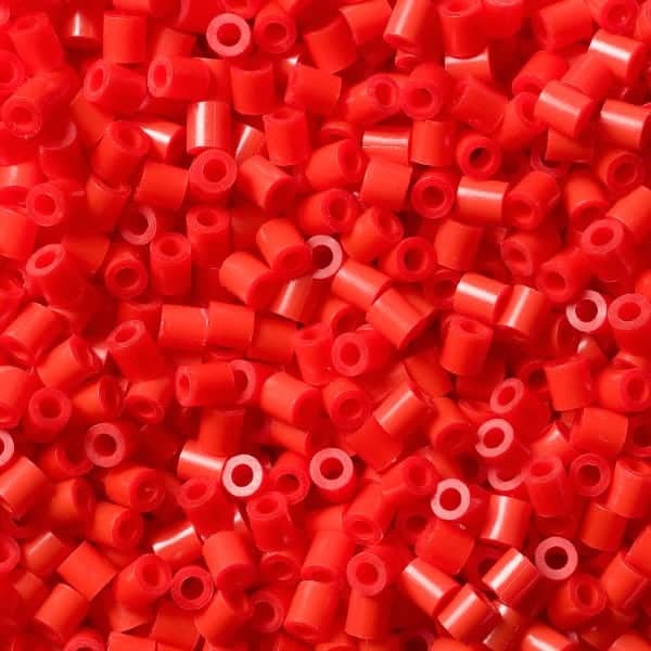 an image of red midi sized hama beads loosely together showing the bright colour
