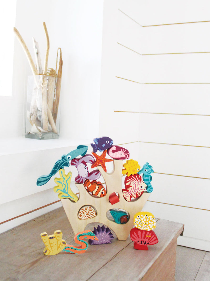 a wooden baby stacking toy with a natural wood coral piece and lots of colourful ocean animals