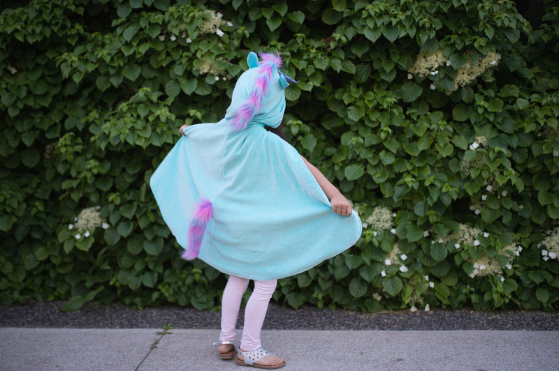 the back of the unicorn side of the reversible cape with blue fluffy fabric and a rainbow tail and main 